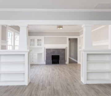 Living Room interior after remodelling with fire place and grey wooden floor for virtual staging.